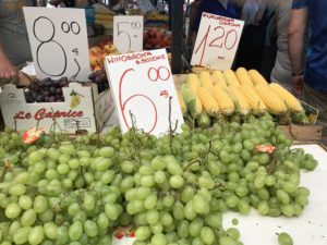 a bunch of grapes and corns at a market