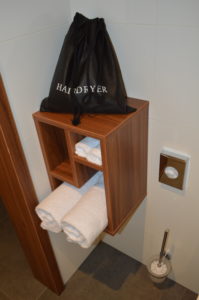 a shelf with towels and a bag on top