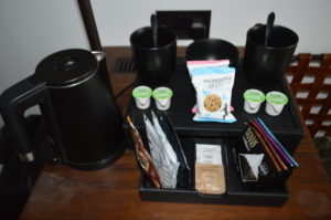 a black tray with coffee cups and a variety of items on it