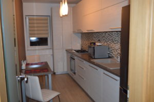 a kitchen with white cabinets and a black refrigerator