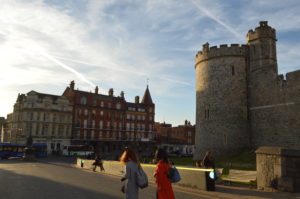 a group of people walking in front of a stone building