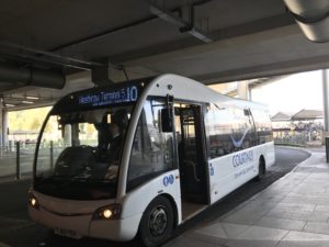 a white bus parked under a bridge