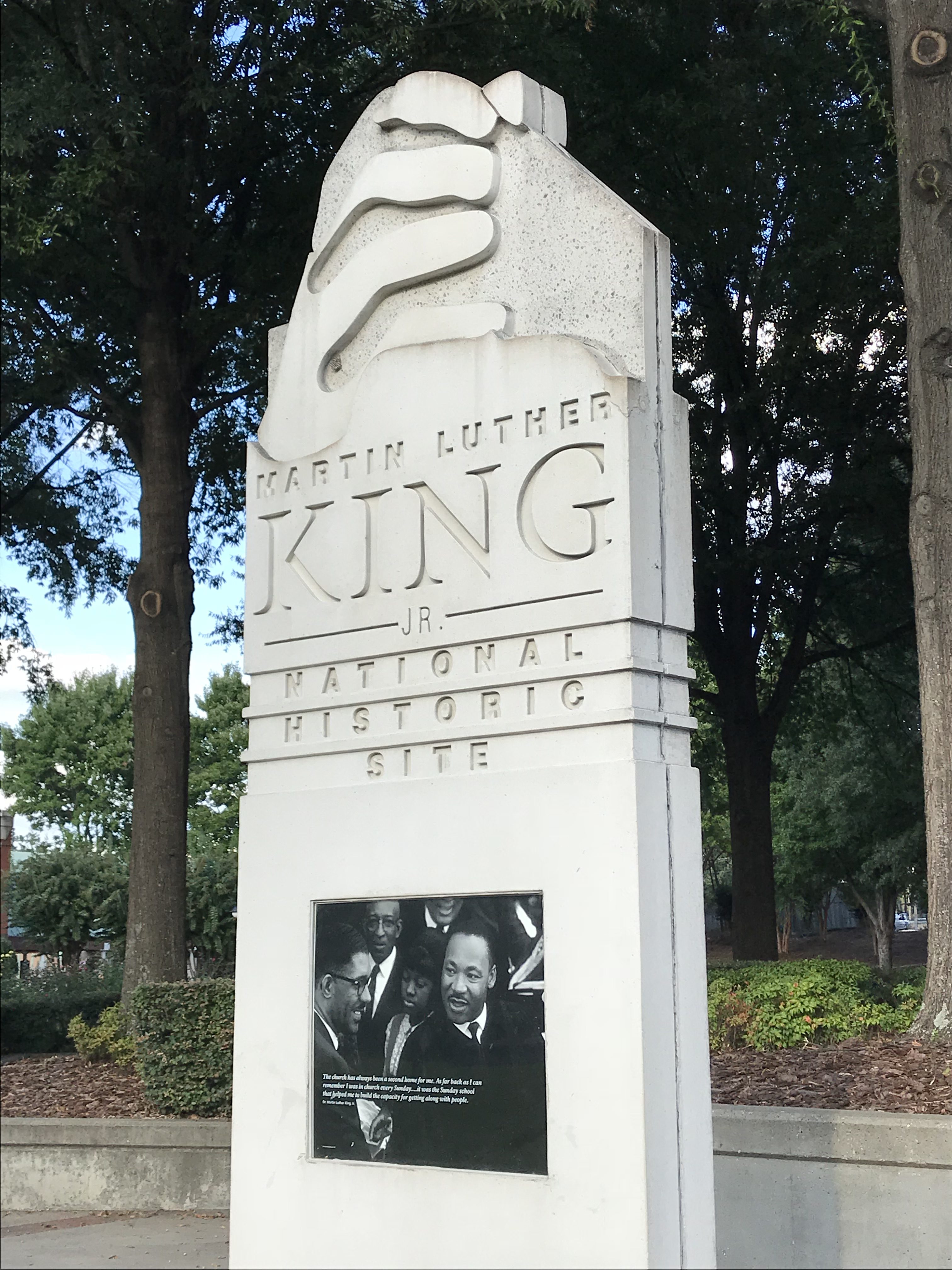a monument with a sign and a picture of a man in a hat