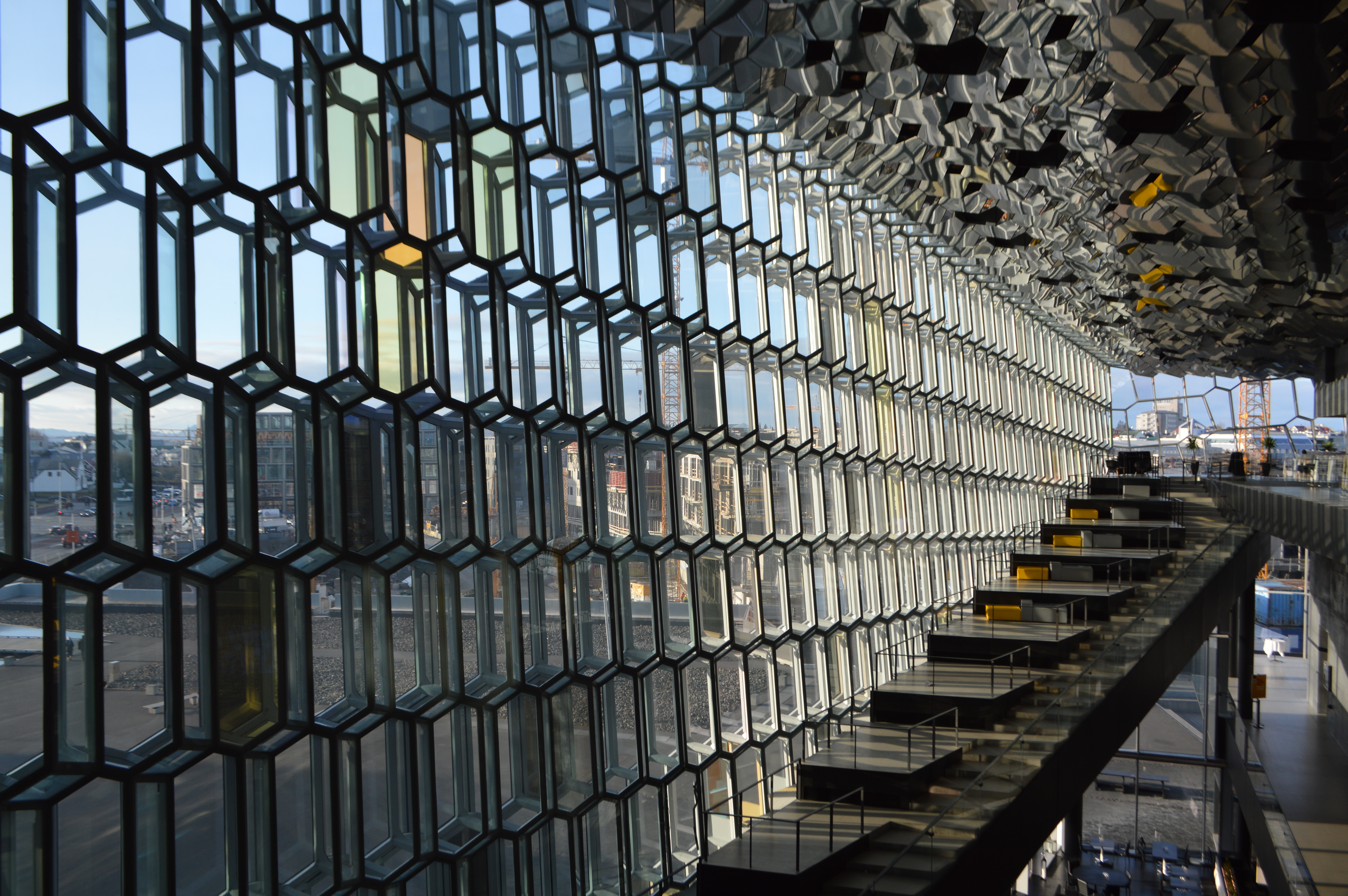 a glass wall with many windows with Harpa in the background