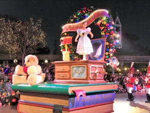 a woman on a stage with a large book and a teddy bear