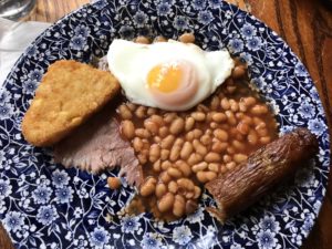a plate of food with a egg and beans