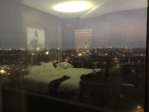 a bed in a room with a city view