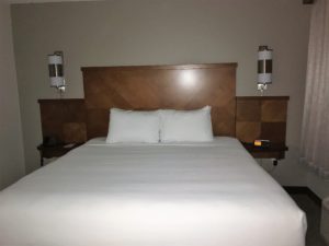 a bed with white sheets and pillows