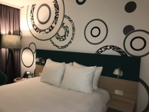 a bed with white pillows and a black and white wall