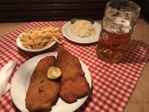 a plate of food and a beer on a table