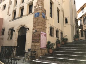 a stone building with stairs and a sign