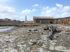 a rocky beach with a building and a tower