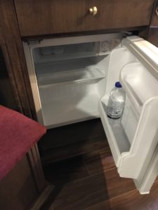 a small refrigerator with a bottle inside