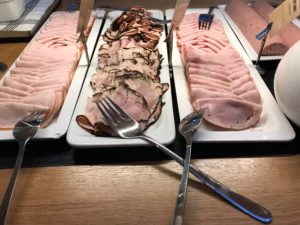 a row of plates with different types of meats