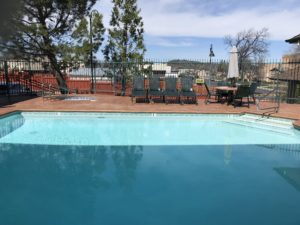 a pool with chairs and a fence