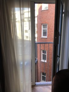 a window with a balcony and a brick building