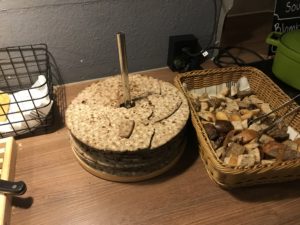 a stack of crackers next to a basket of bread