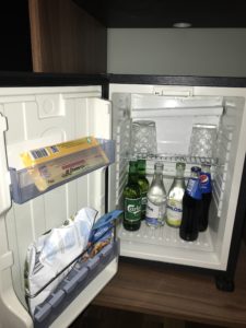 a mini fridge with bottles and drinks inside