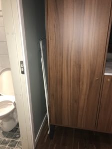 a wooden cabinet next to a toilet