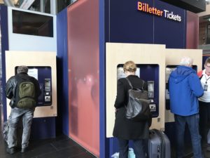 people standing in front of a ticket machine