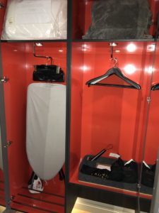 a closet with ironing board and swingers