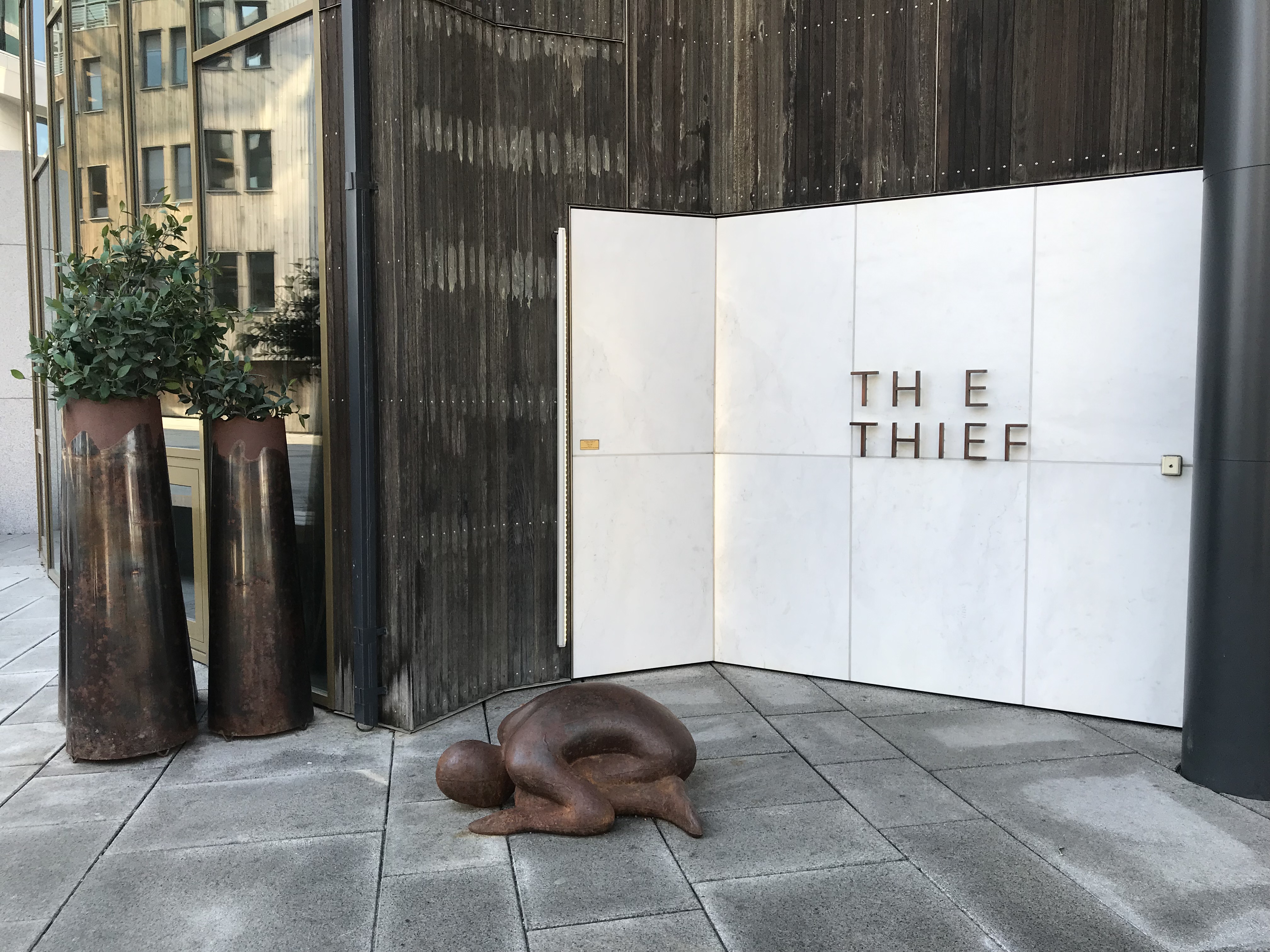 a statue of a person lying on the ground outside of a building