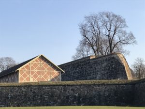 a stone wall with a building in the background