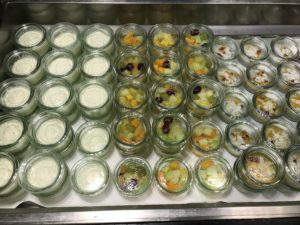 a tray of small glass jars with different toppings