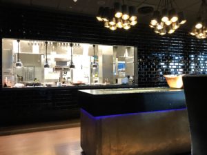 a kitchen with a black counter and lights