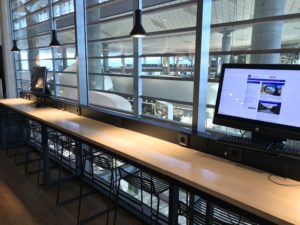 a desk with a computer and a table with stools