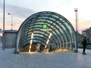 a glass tunnel with a green sign