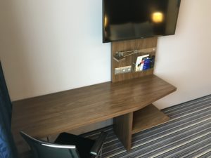 a desk with a tv on the wall