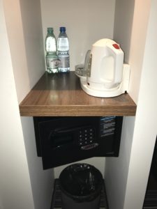 a small black safe with a white kettle and two bottles of water on it