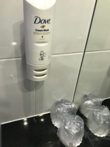 a white soap dispenser on a tile wall