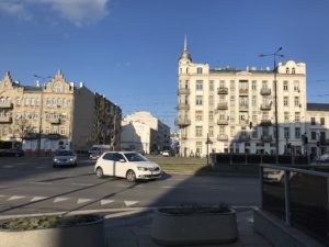 a white car on a street with buildings in the background