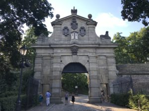 a stone archway with people walking around