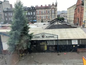 a building with a fence and a tree in the background