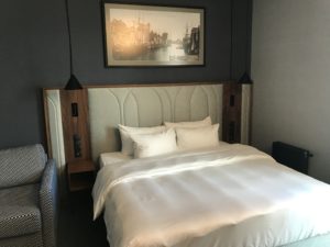 a bed with pillows and a picture on the wall