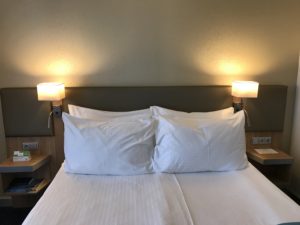 a bed with white pillows and two lamps