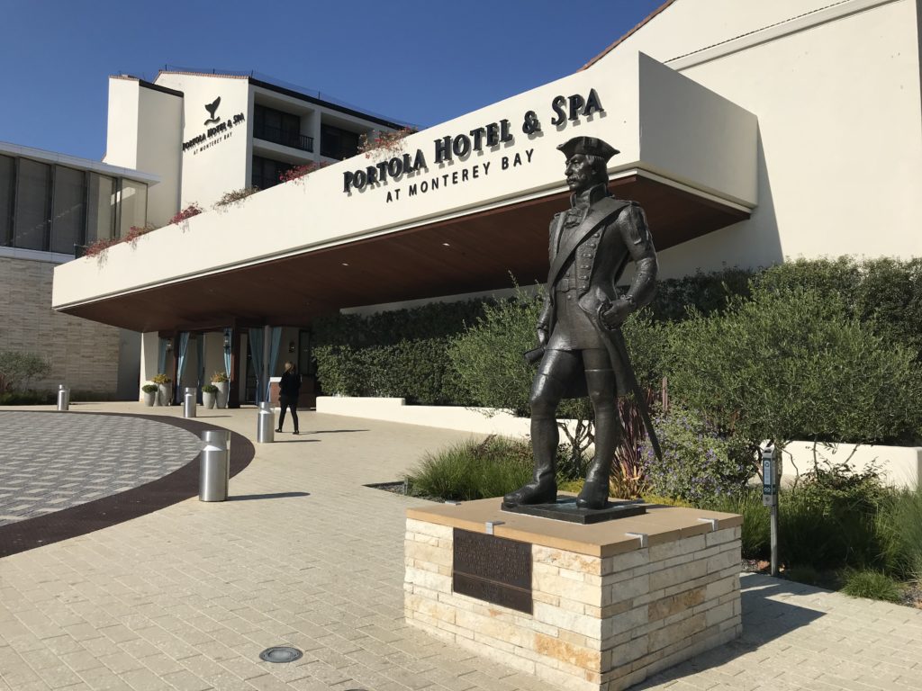 a statue of a man in a uniform outside of a hotel