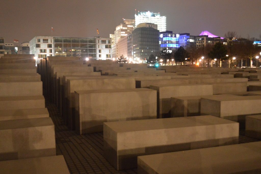 a large concrete structure with buildings in the background