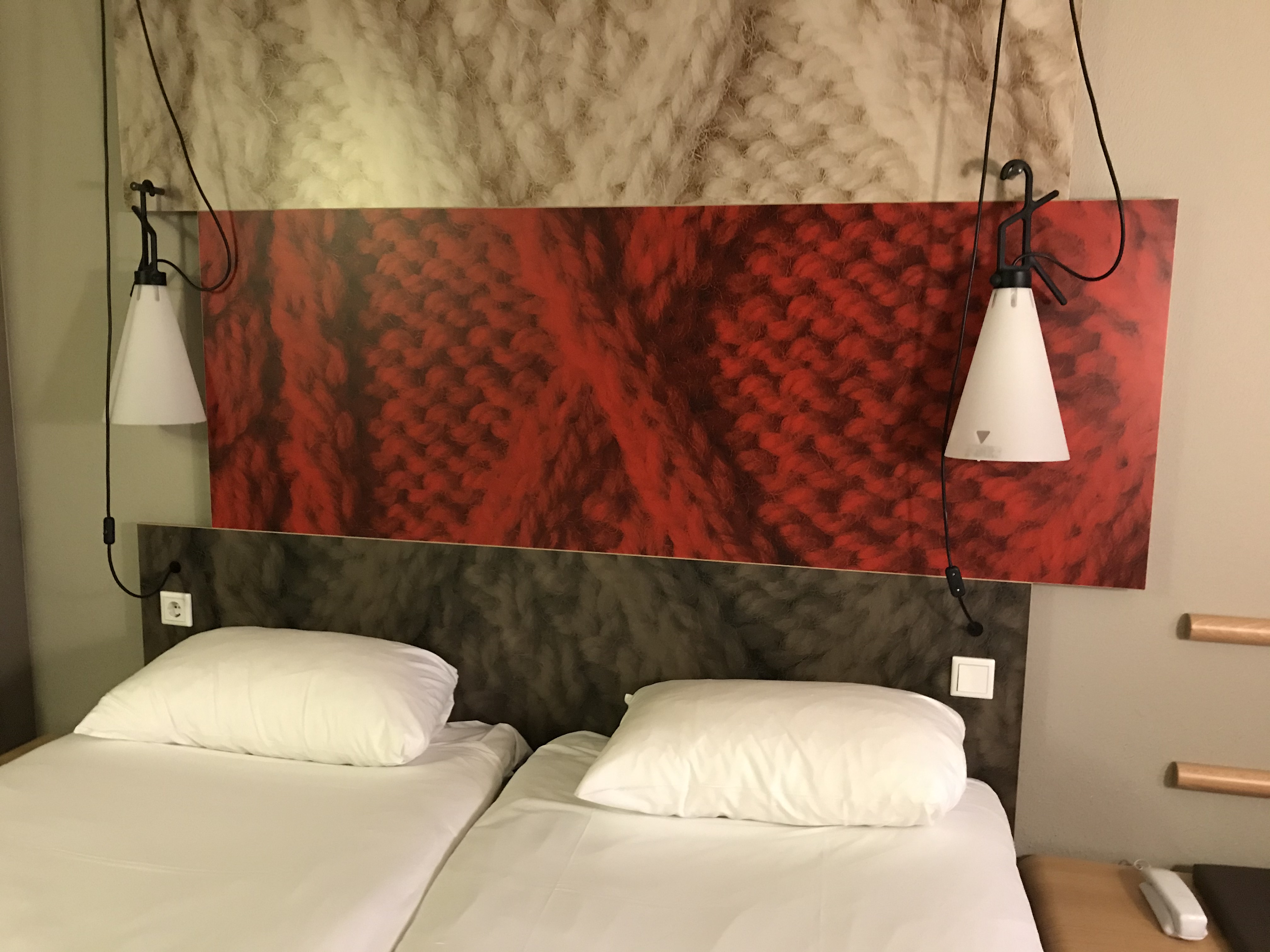 a bed with white sheets and lamps