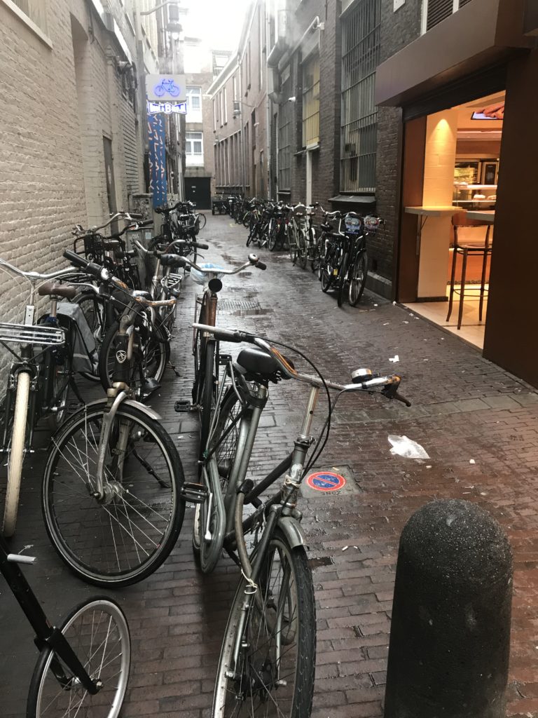 a group of bicycles parked on a brick alleyway