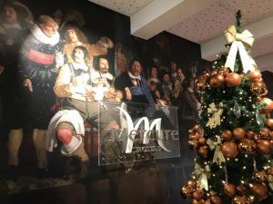 a christmas tree with a painting on the wall