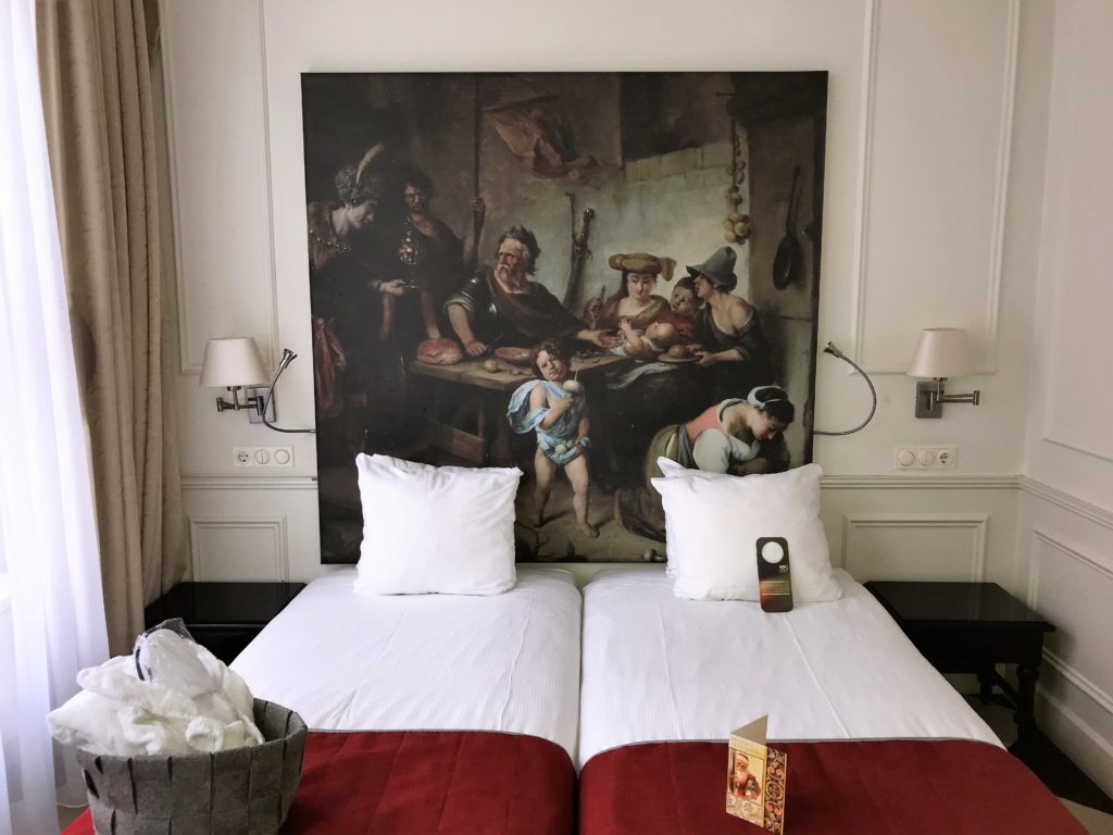 a bed with a painting on the wall