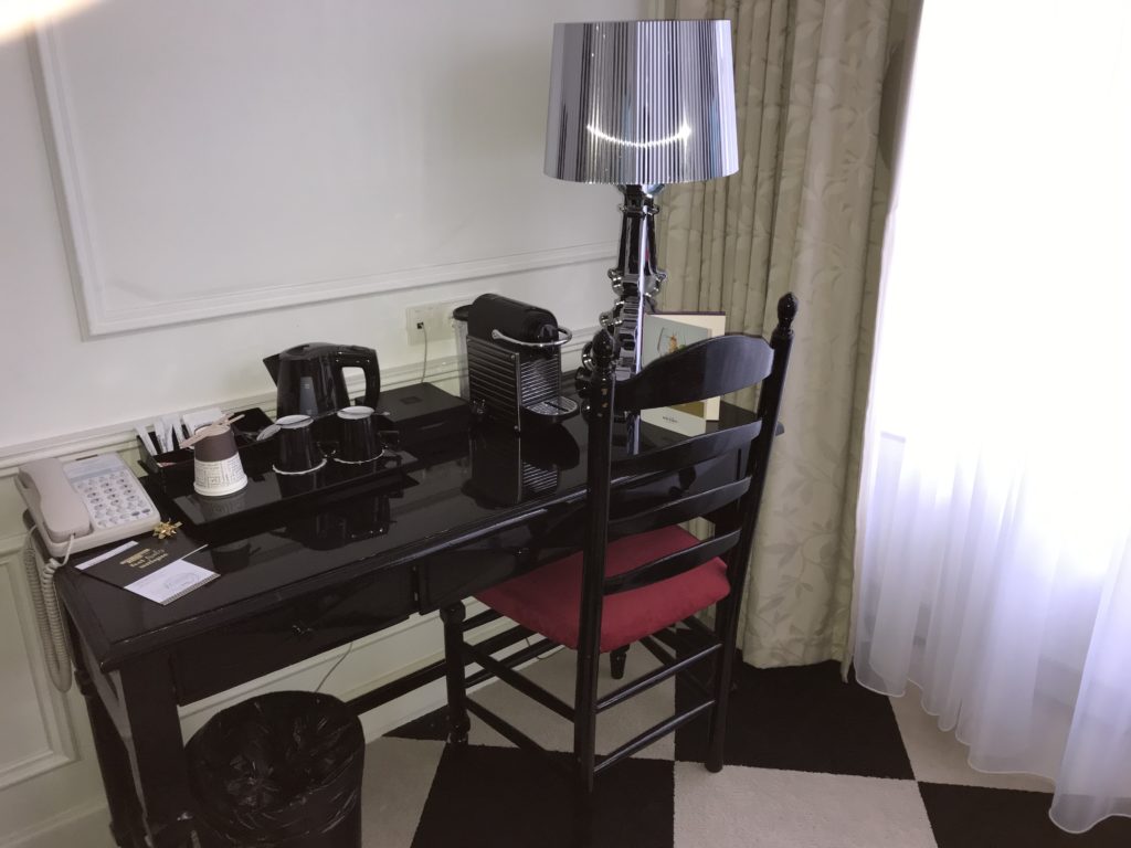a black desk with a lamp and a chair