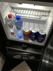 a refrigerator with bottles of soda and cans