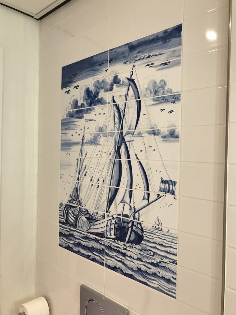 a tile wall with a painting of a sailboat