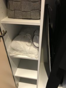 a white shelf with a bag and shoes