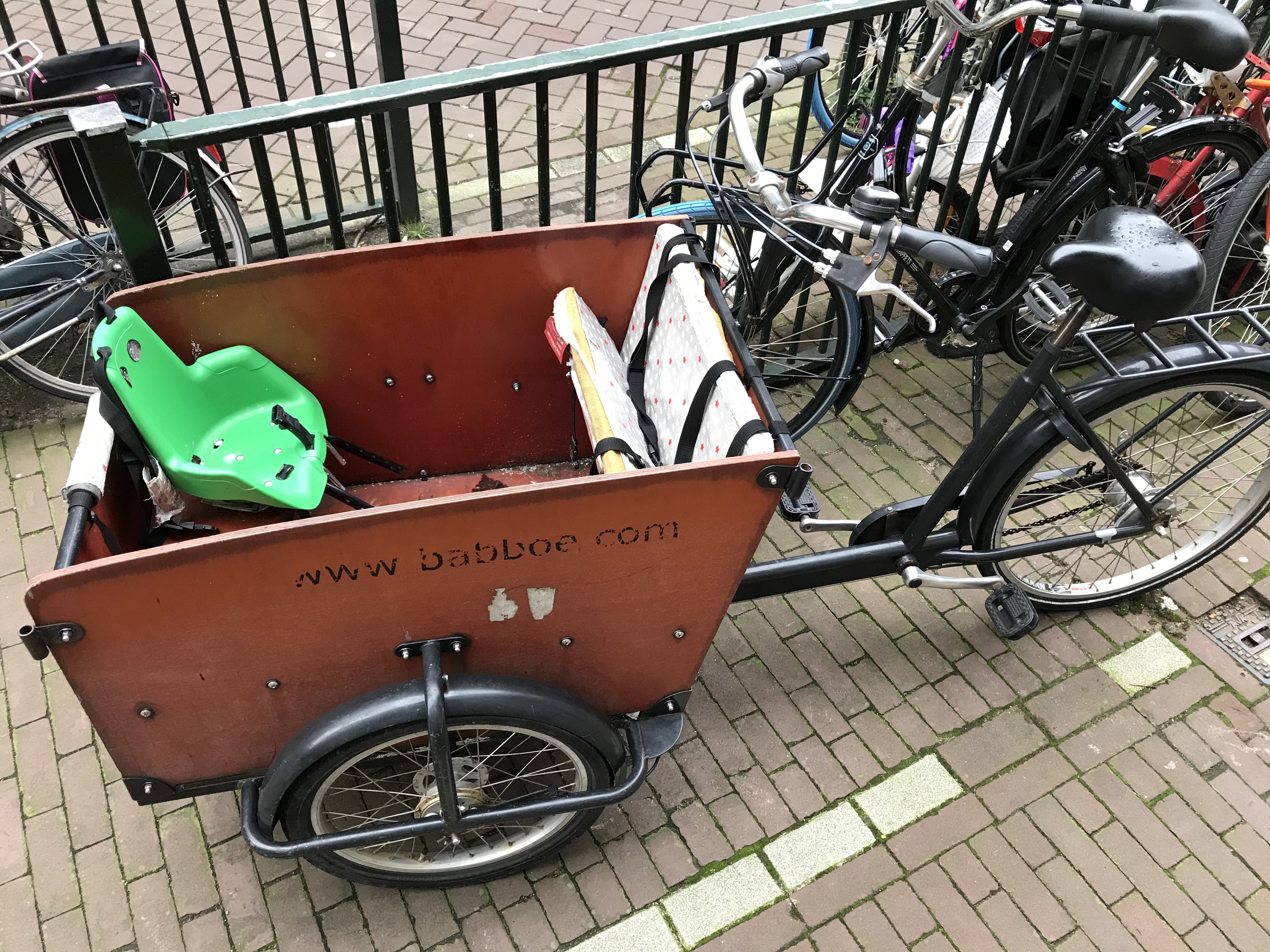 a bicycle with a cart and a green seat